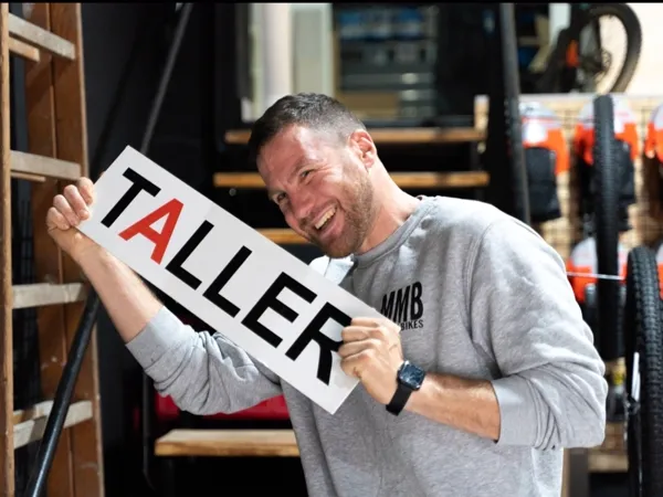 Javier con el cartel del taller de Madma Bikes